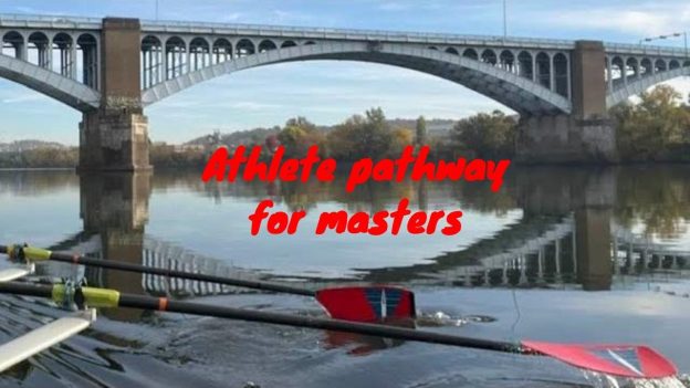 A rowing boat going under a bridge with red and blue oars,