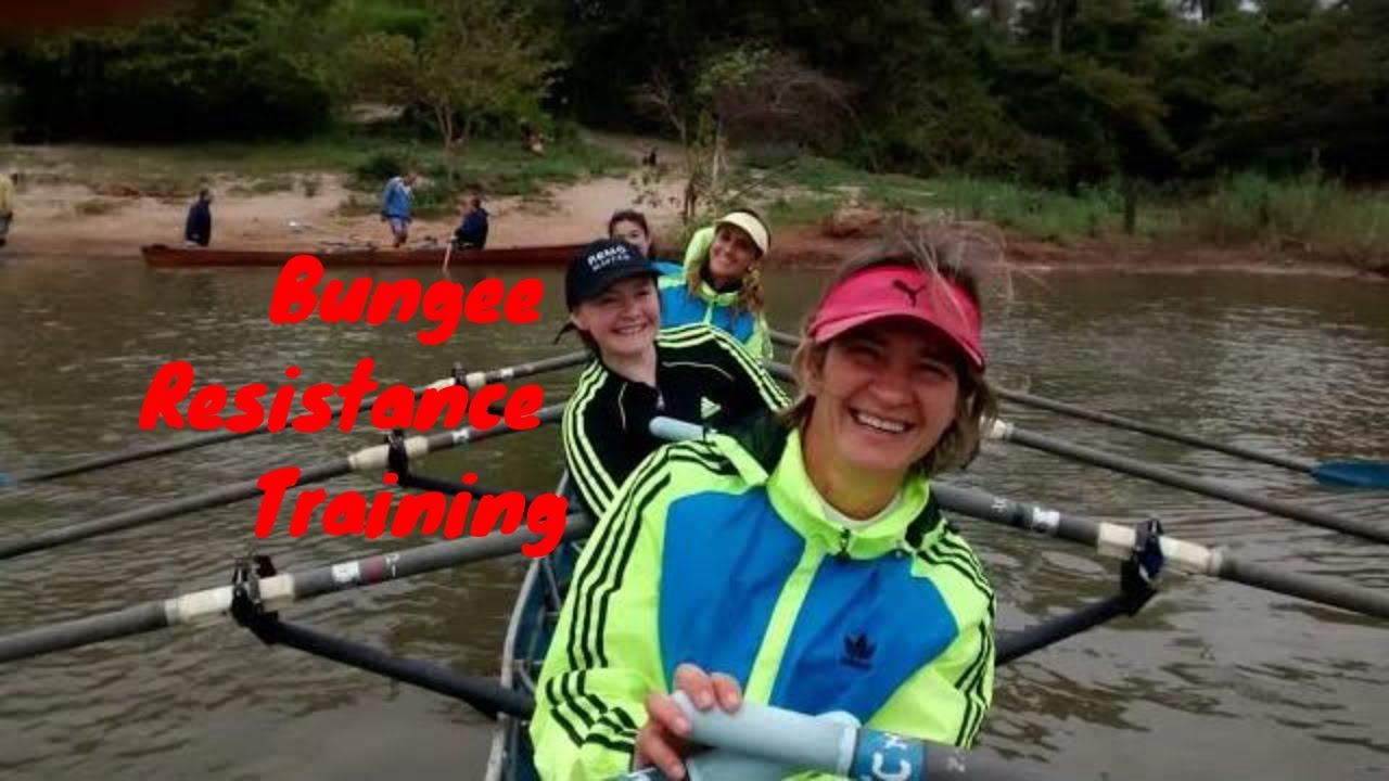 four smiling women in a quad scull rowing boat.