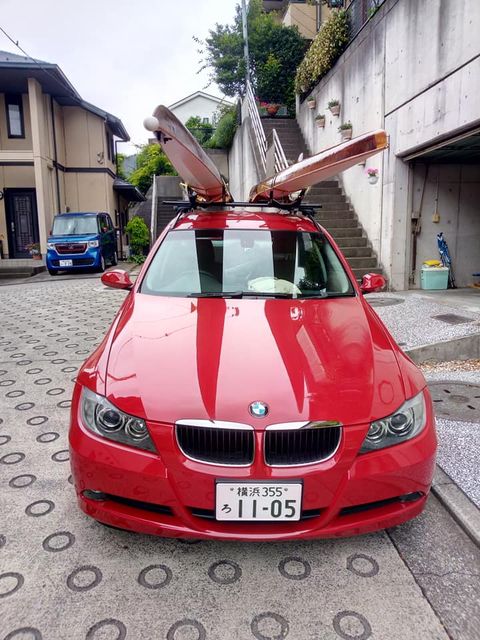 red car with two rowing boats on the roof rack