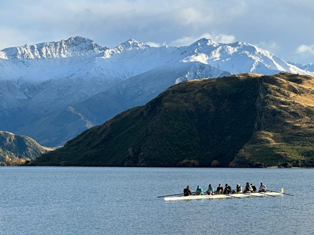 rowing eight with snowy mountains on Lake Wanaka New Zealand
