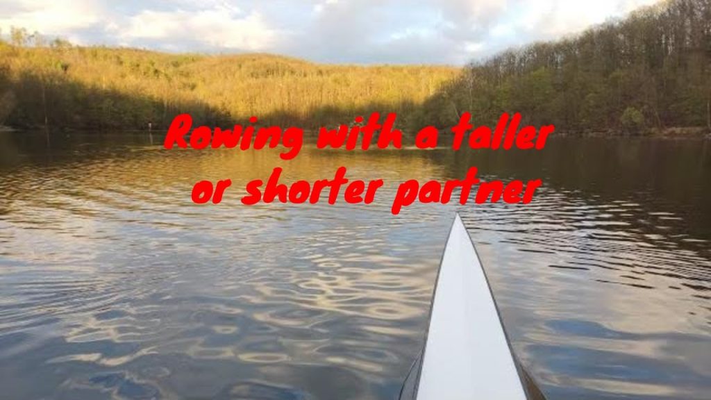 Rowing boat bow on a large lake, tree lined shore, slight water ripples