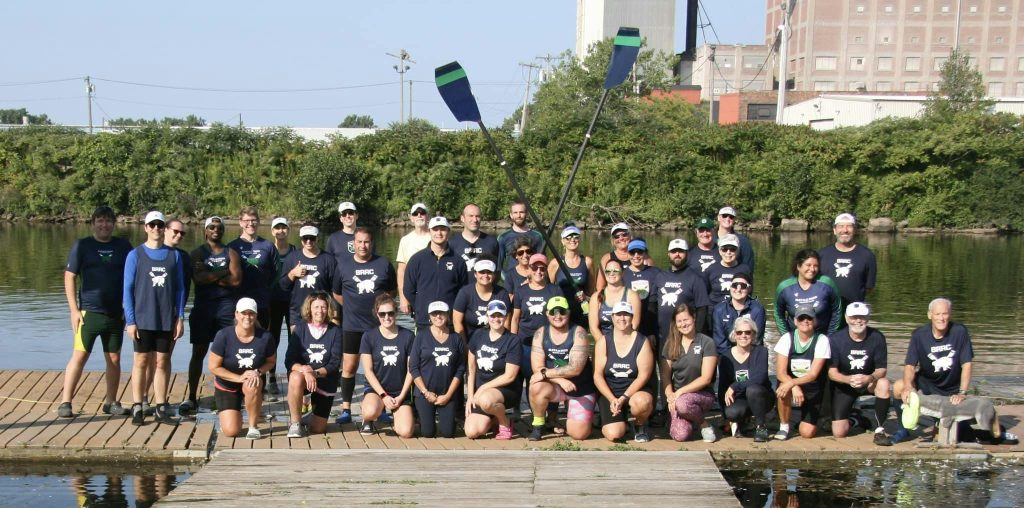 Group of older masters rowers on a wooden dock with crossed oars