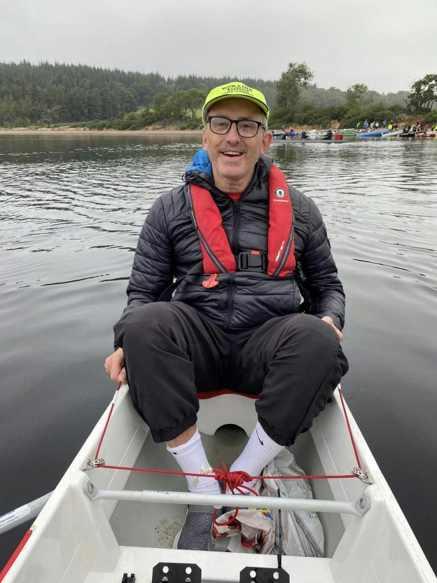 Older rowing coxswain in a boat