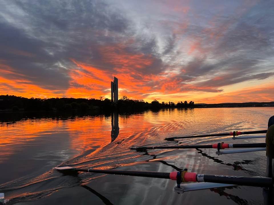 red sunrise over a lake with rowing boat in foreground
