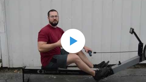 Man sitting on rowing machine explaining