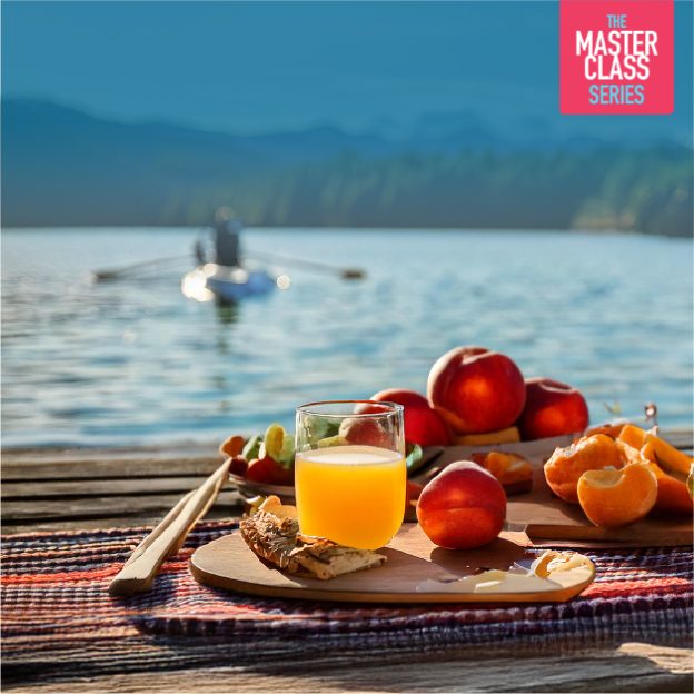 picnic table with healthy food and a rowing boat in the background