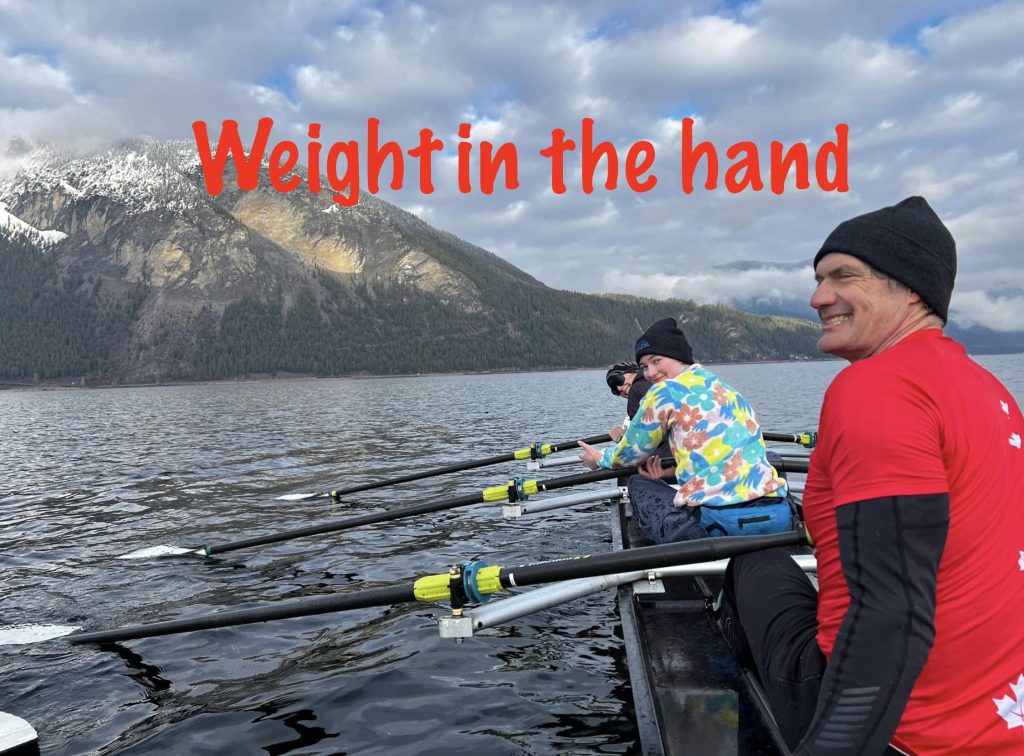 Three people in a rowing boat in Canada during winter. Mountains, snow and smiles