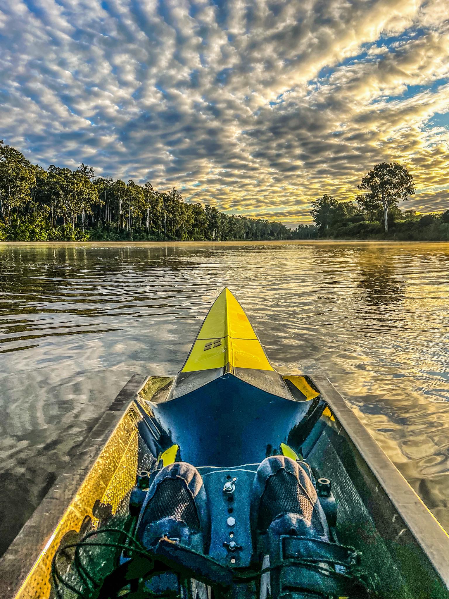 herringbone clouds above a river with a yelloe rowing boat in foreground