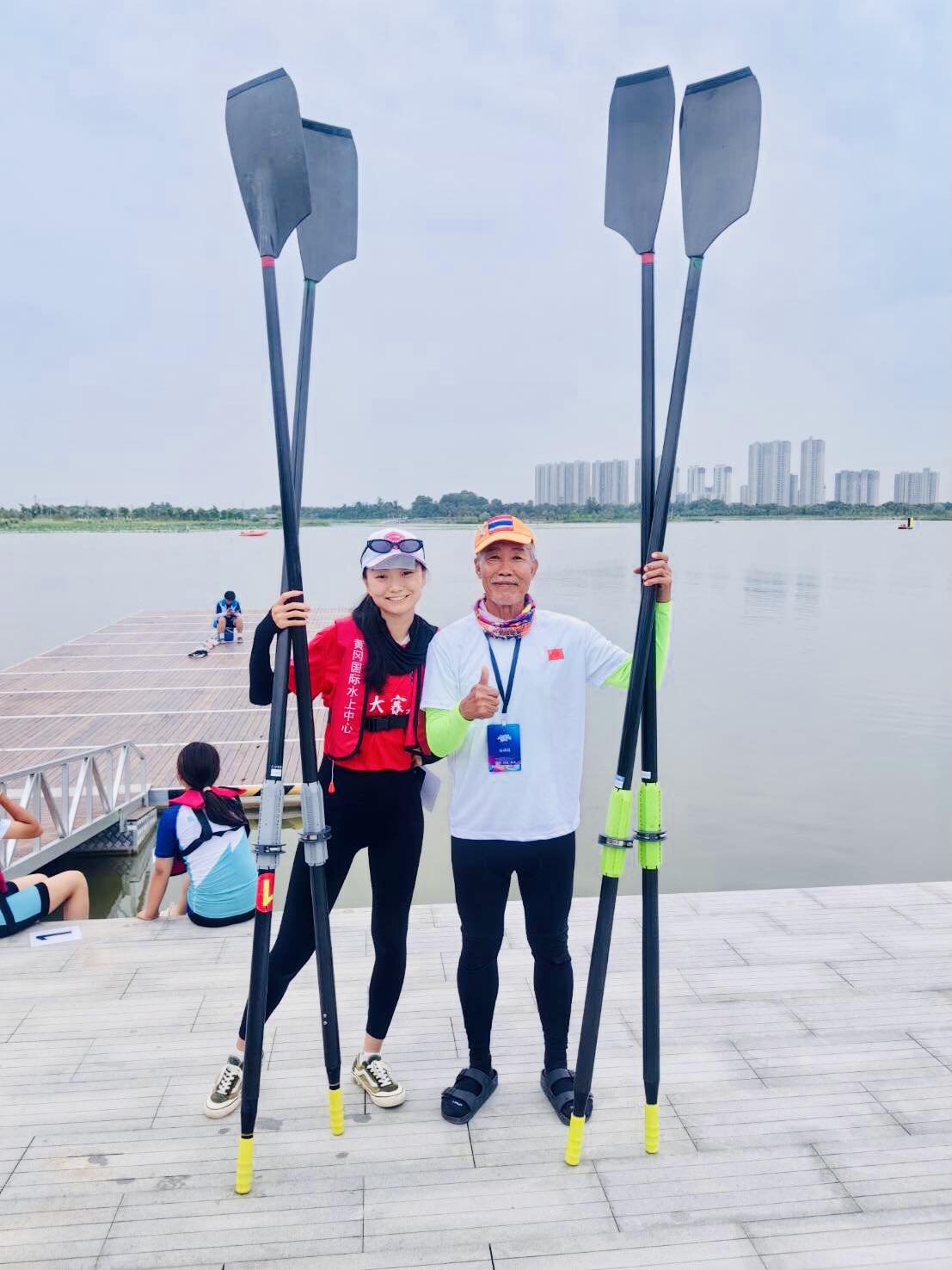 two rowers holding oars vertically father daughter